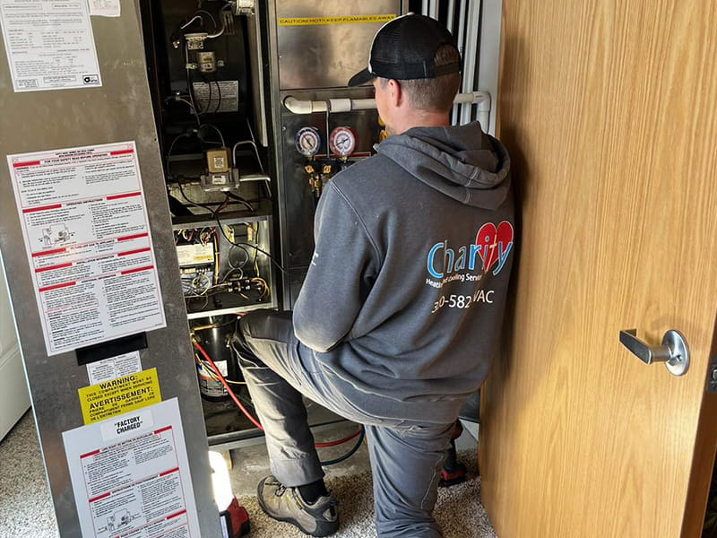 charity hvac tech working on open furnace