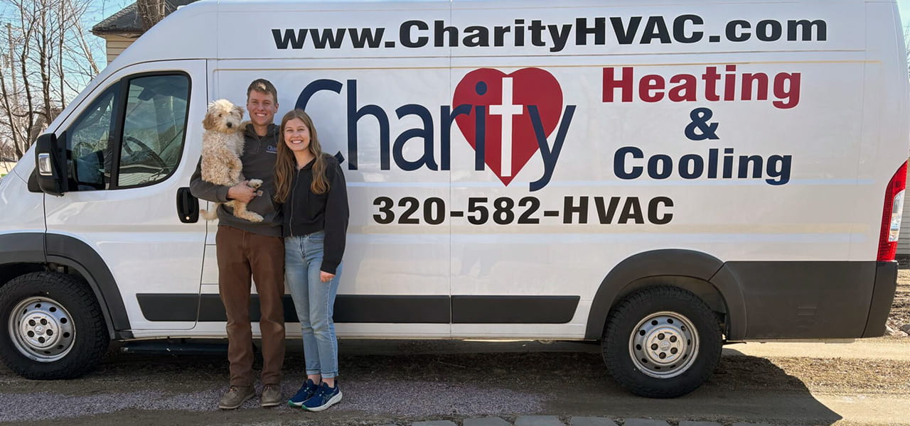 technician eddie standing with wife and dog in front of charity hvac van