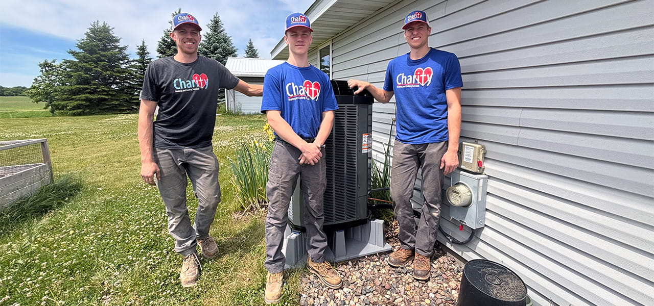 eddie luke and apprentice standing with installed outdoor ac unit